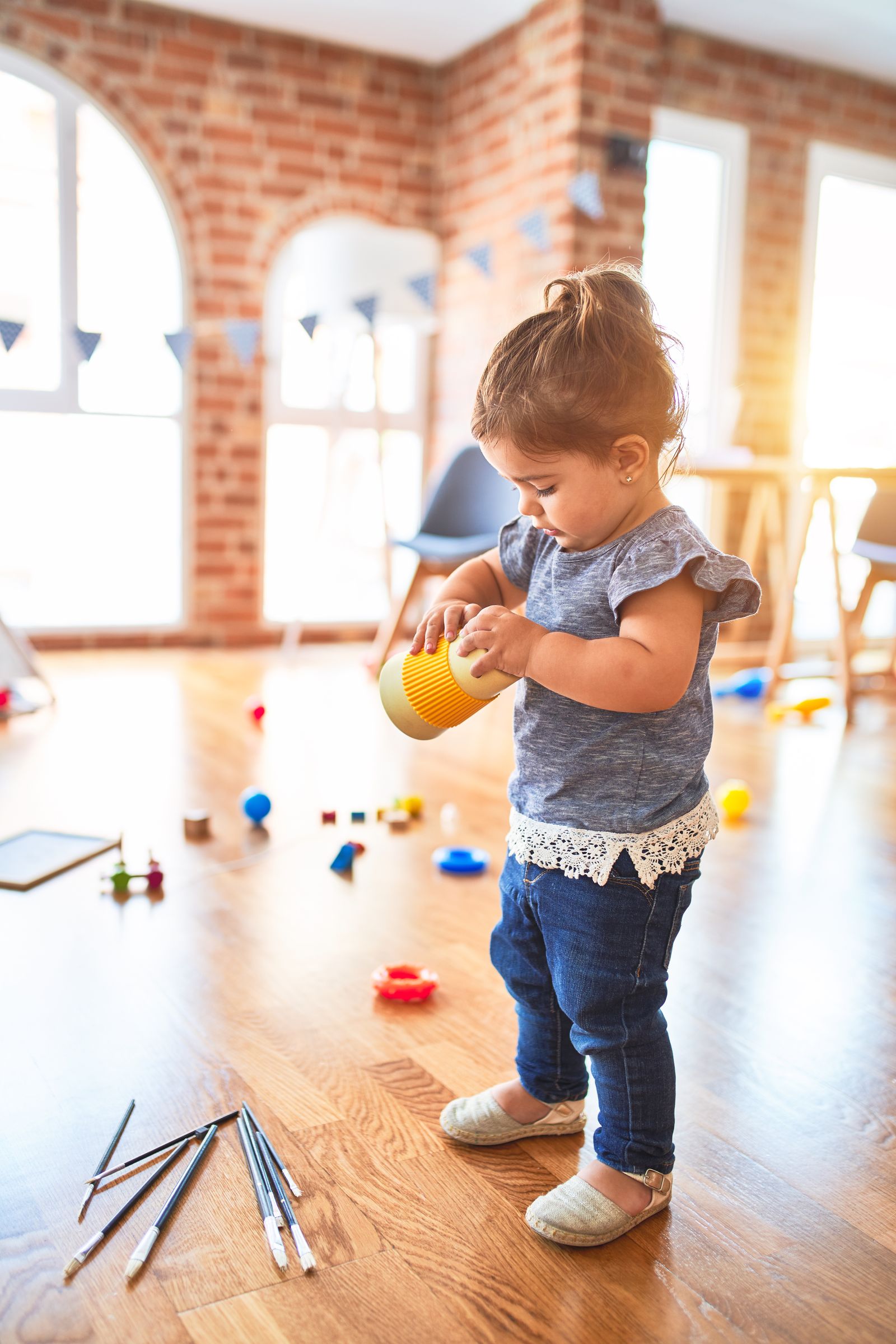Toddler playing with toys in a bright nursery setting